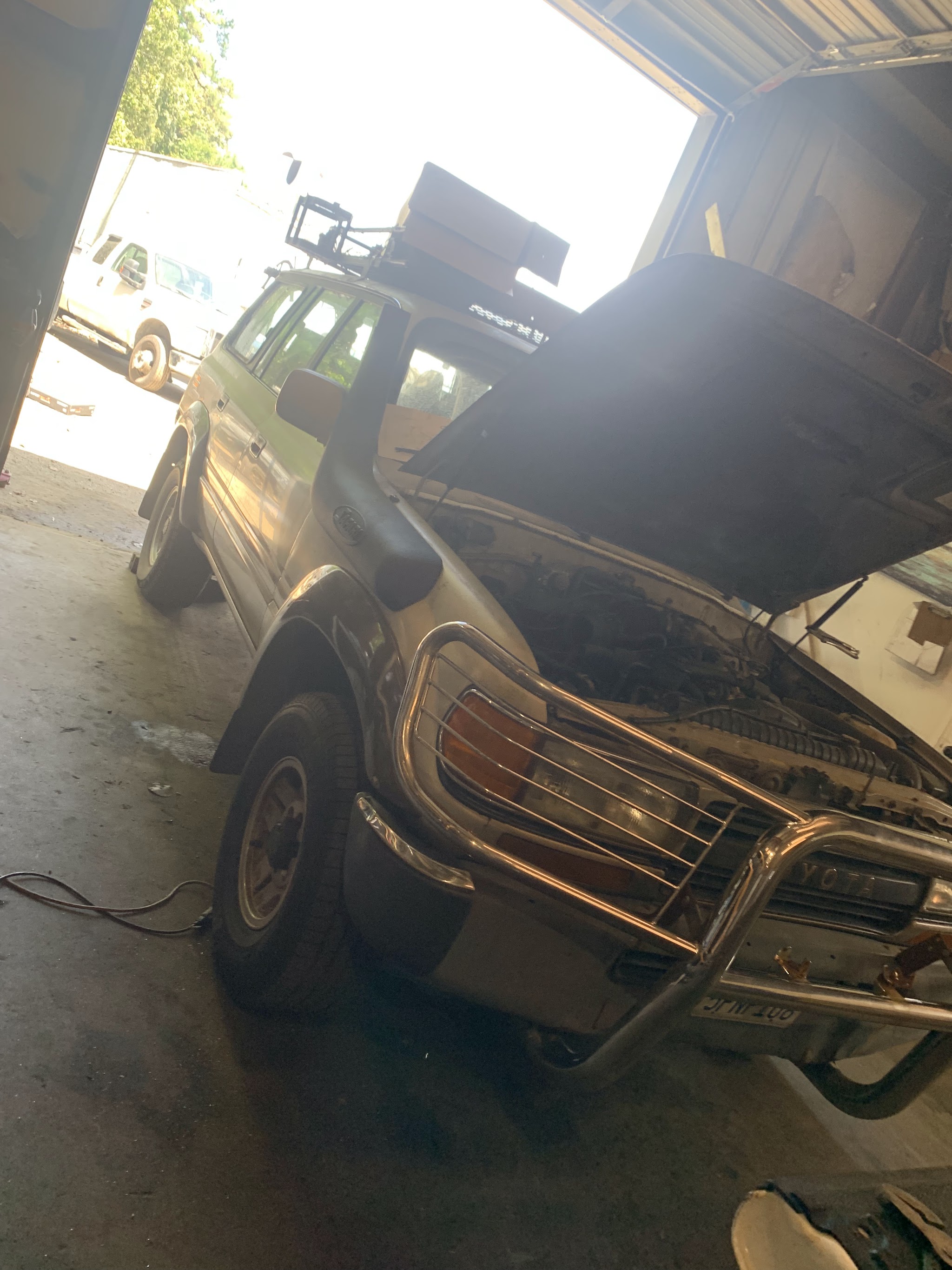 An SUV in the bay with the hood up